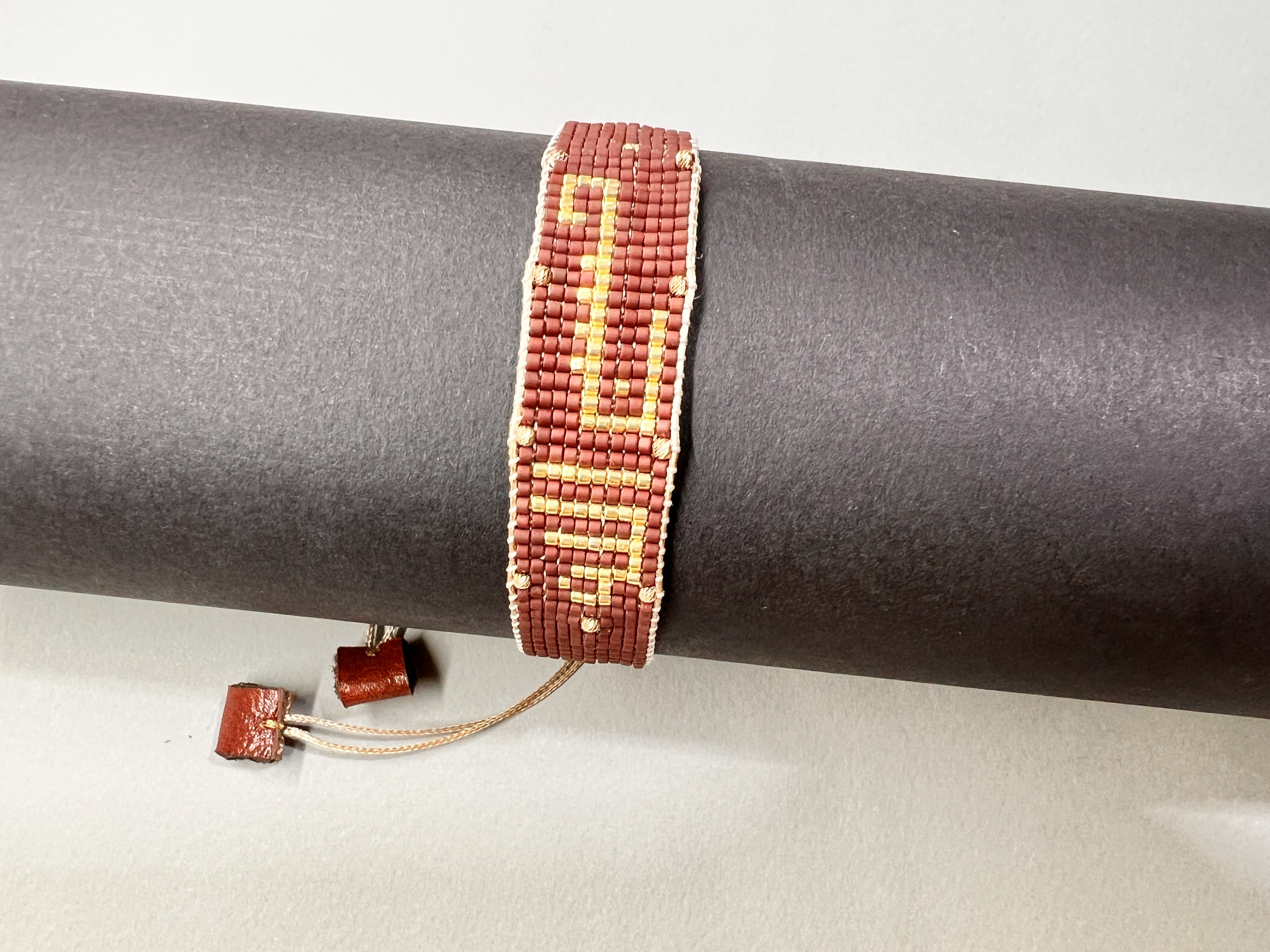 دستبند میوکی با نام خدا طیف رنگ قهوه‌ای طلایی